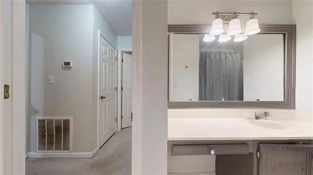 an empty room that has a chandelier fan and a window