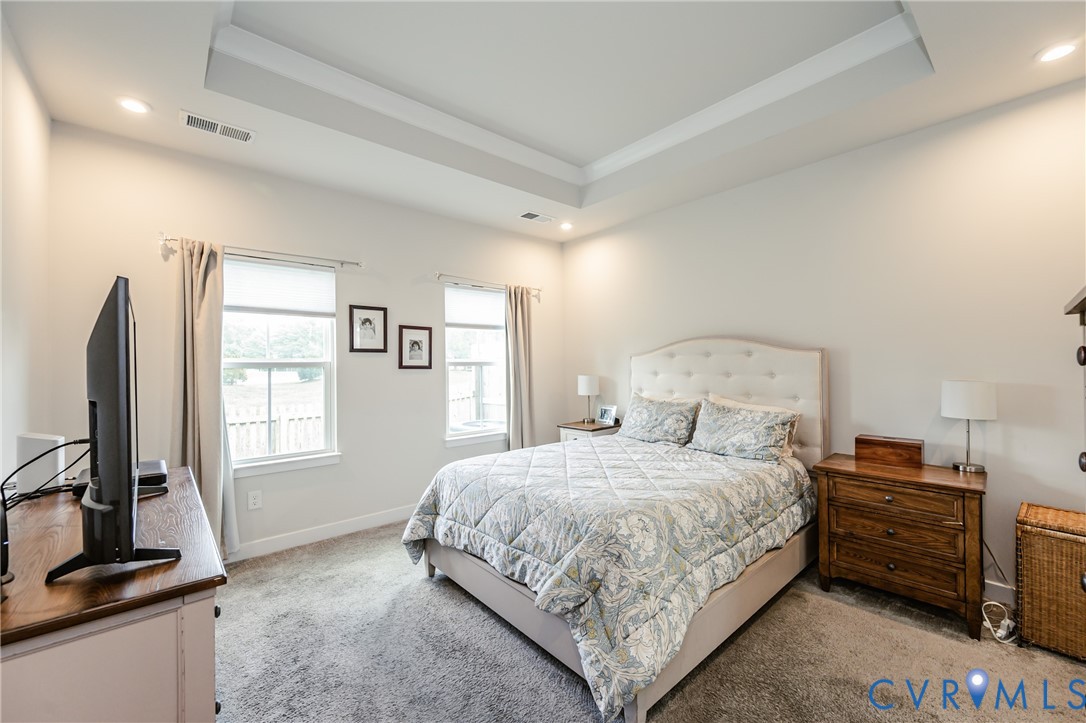 9073 Spring Green Loop Mechanicsville, VA 23116 - Photo 19 of 31 a bedroom with a bed and a flat tv screen on the dresser
