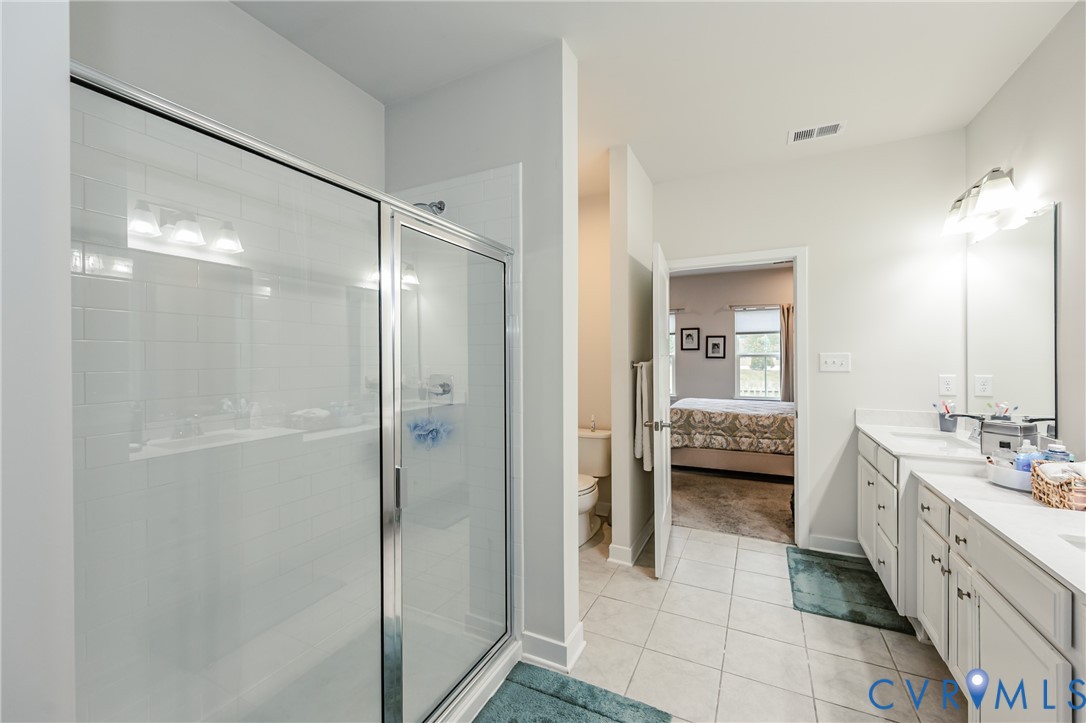 9073 Spring Green Loop Mechanicsville, VA 23116 - Photo 20 of 31 a bathroom with a double vanity sink a mirror and a shower