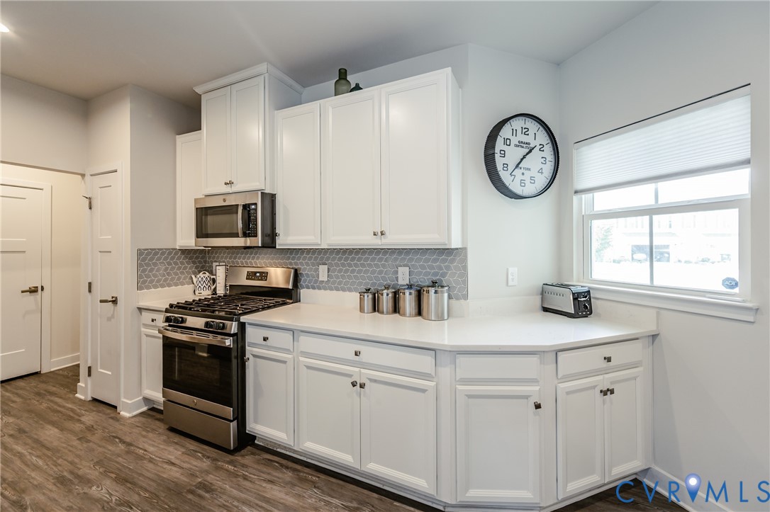 9073 Spring Green Loop Mechanicsville, VA 23116 - Photo 7 of 31 a kitchen with white cabinets and stainless steel appliances