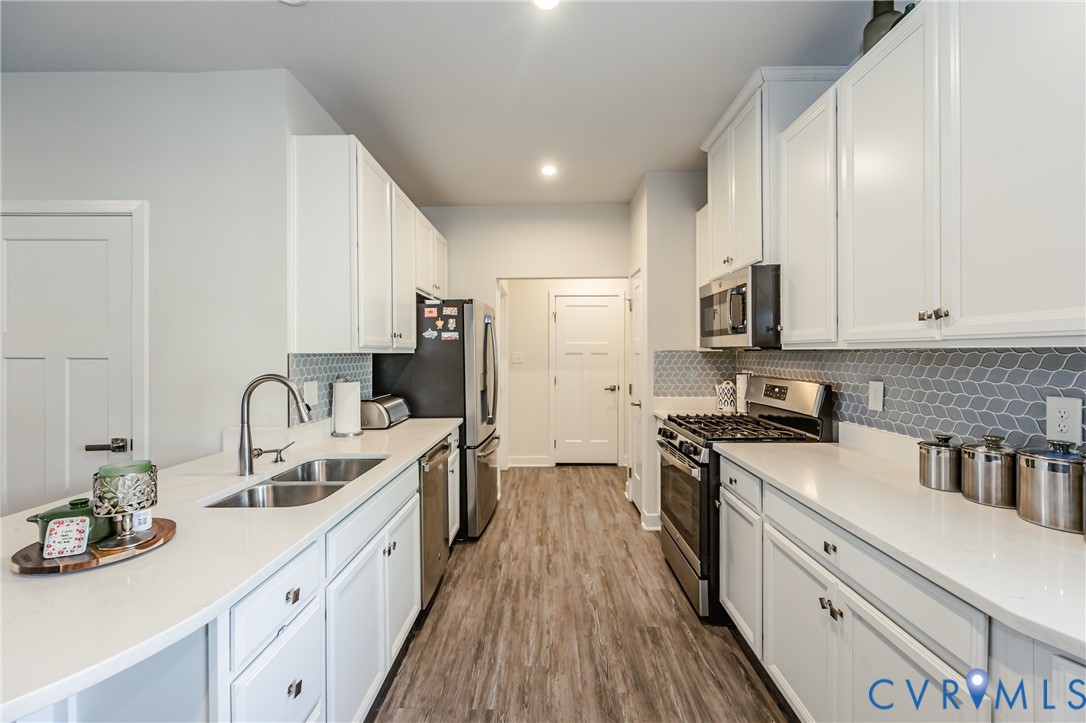 9073 Spring Green Loop Mechanicsville, VA 23116 - Photo 10 of 31 a kitchen with stainless steel appliances granite countertop a sink stove refrigerator and cabinets