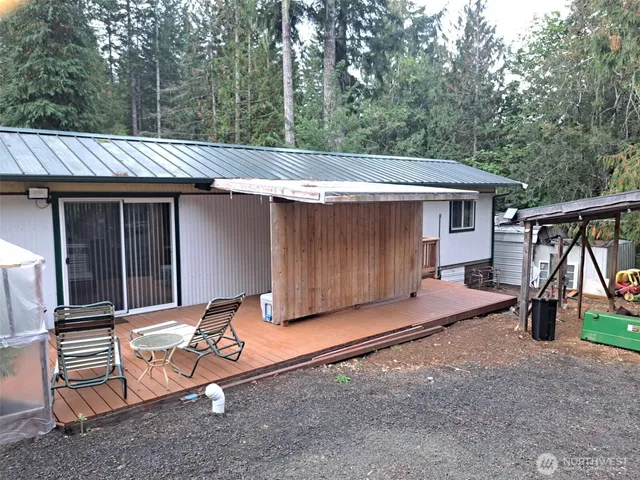 a backyard of a house with barbeque oven table and chairs