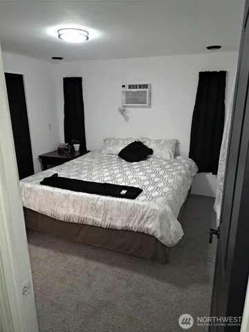 a bedroom with a bed and a flat screen television