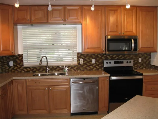 a kitchen with stainless steel appliances granite countertop a sink stove and microwave