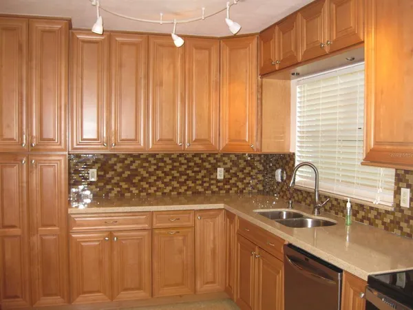 a kitchen with stainless steel appliances a sink cabinets and a window