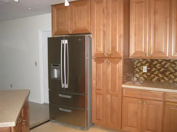 a view of a kitchen with white cabinets and a refrigerator