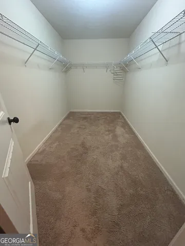 an empty room with closet and mirror