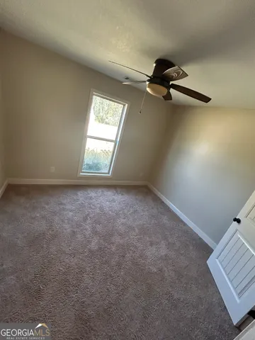 an empty room with a fireplace and wooden floor