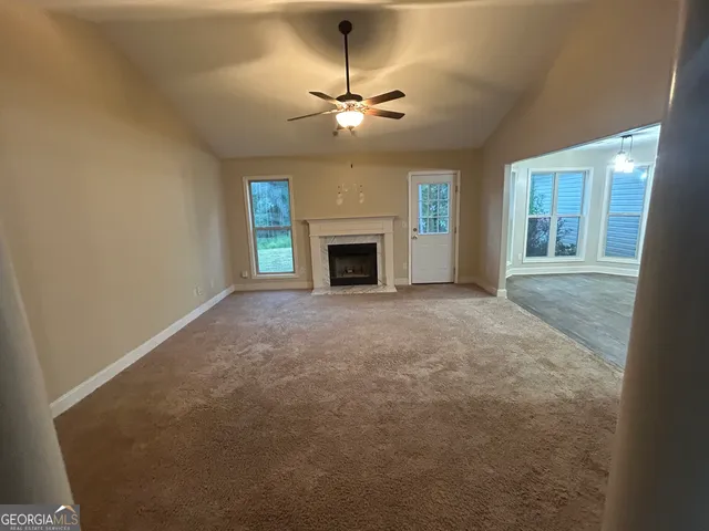 a view of a livingroom with a fireplace and a chandelier fan