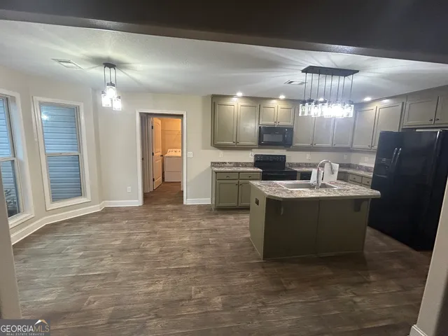 a view of a kitchen with a sink stainless steel appliances cabinets and dining table
