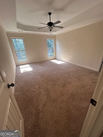 en empty room with windows and ceiling fan