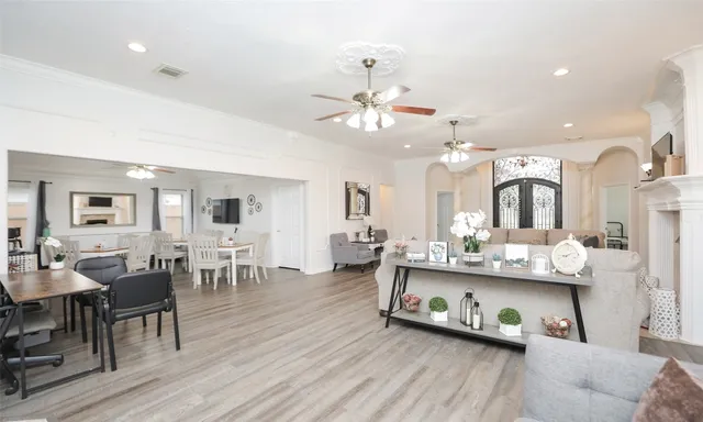 a living room with furniture kitchen view and a wooden floor