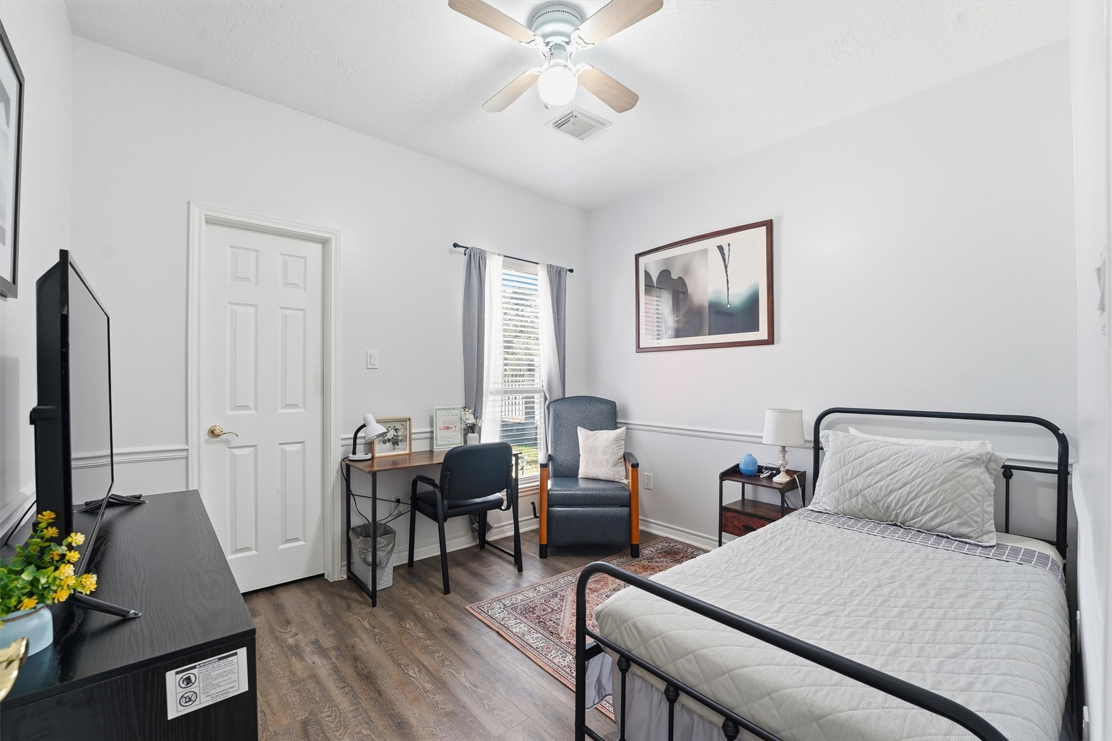 14103 Smith Road Humble, TX 77396 - Photo 14 of 39 a bedroom with a bed and a chandelier