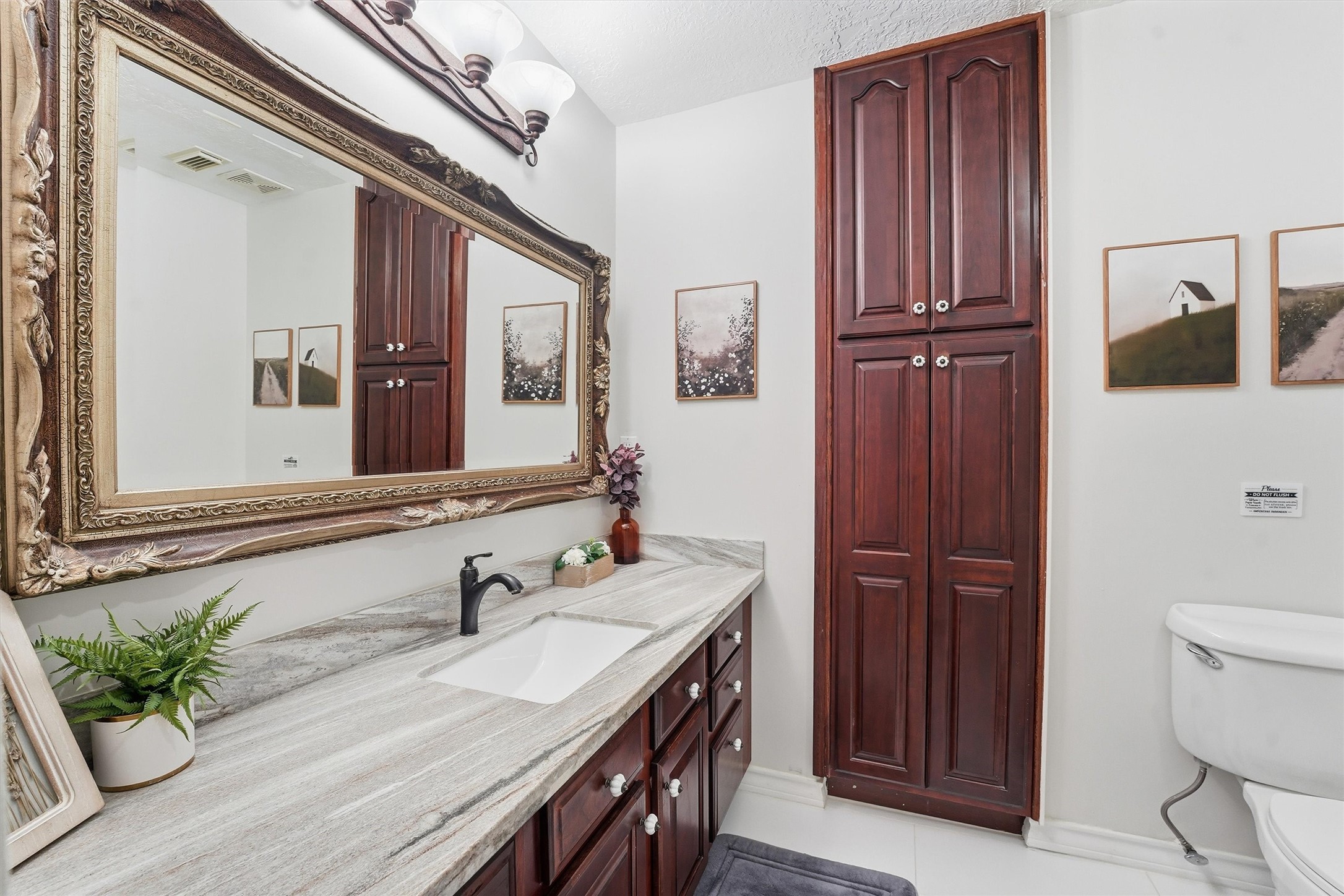 14103 Smith Road Humble, TX 77396 - Photo 16 of 39 a bathroom with a granite countertop sink a toilet and a mirror