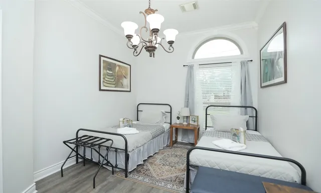 a bedroom with a bed wooden floor and window