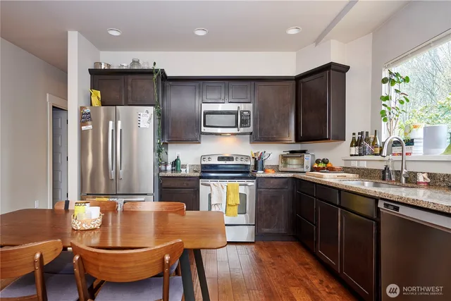 a kitchen with sink refrigerator dining table and chairs