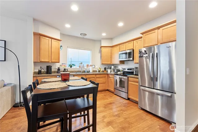 a kitchen with a refrigerator a sink dishwasher and a stove with wooden floor