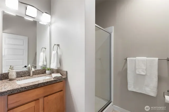 a bathroom with a granite countertop sink and a mirror