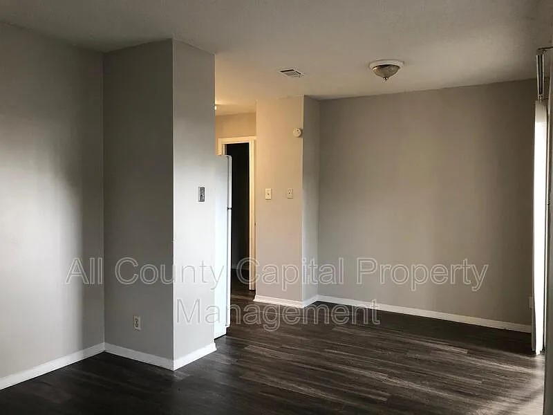6508 South 1st Street, Unit 101 Austin, TX 78745 - Photo 8 of 8 an empty room with wooden floor and entrance