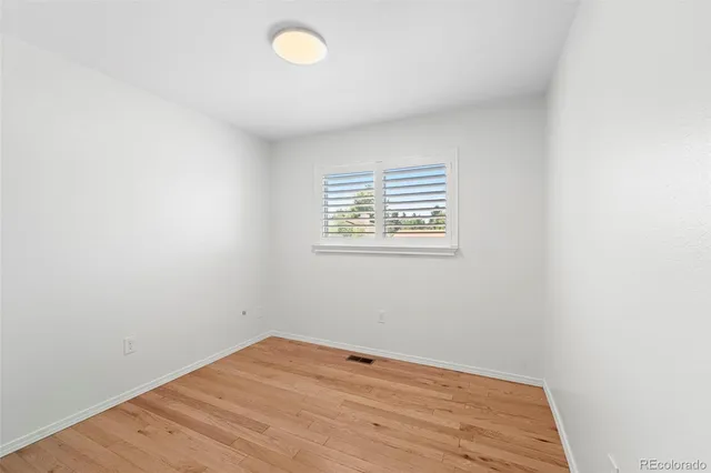 a view of empty room with wooden floor