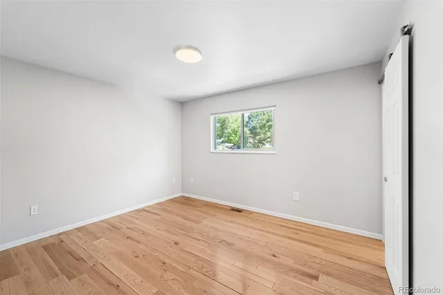 a view of empty room with wooden floor