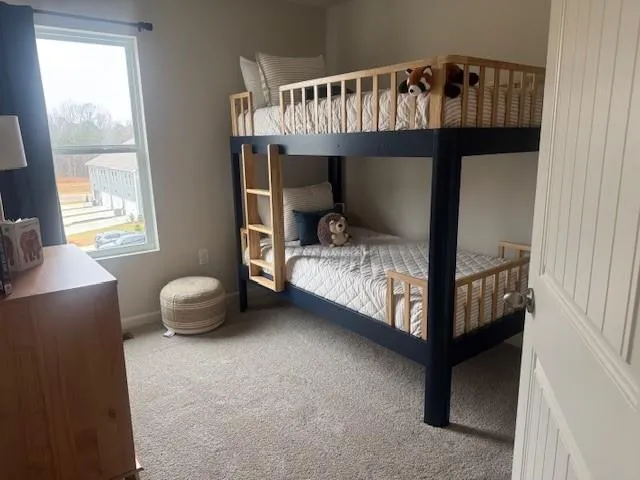 a bedroom with a bunk bed and a window