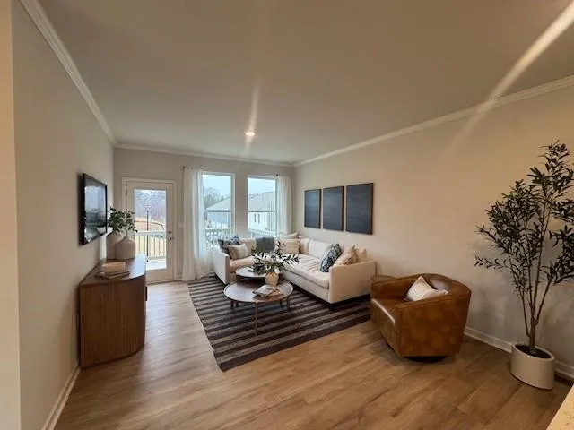 a living room with furniture wooden floor and a large window
