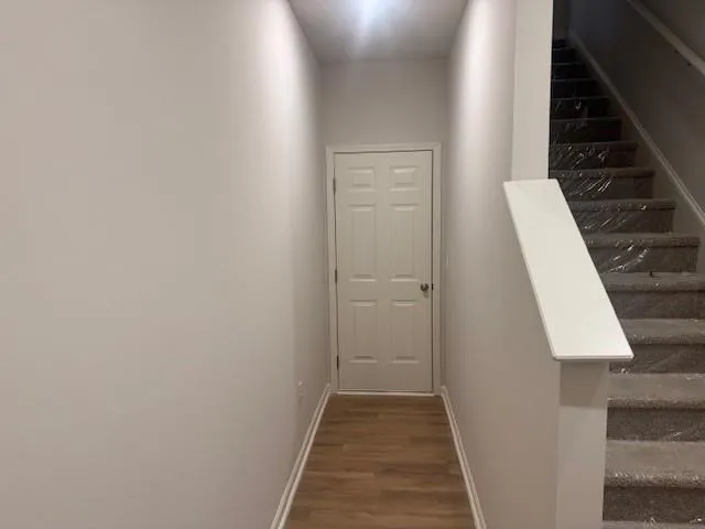 a view of a hallway with wooden floor and staircase
