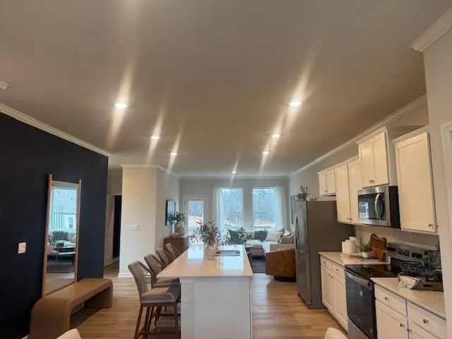 a view of a dining room with furniture a kitchen and chandelier