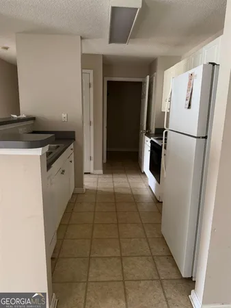 a kitchen with granite countertop a refrigerator and a stove