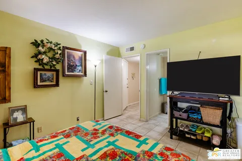 a bedroom with a bed and a flat screen tv