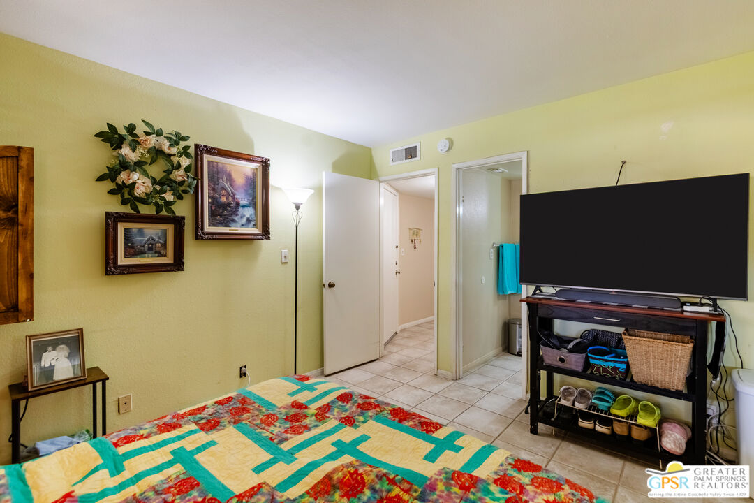 5300 East Waverly Drive, Unit C13 Palm Springs, CA 92264 - Photo 14 of 32 a bedroom with a bed and a flat screen tv
