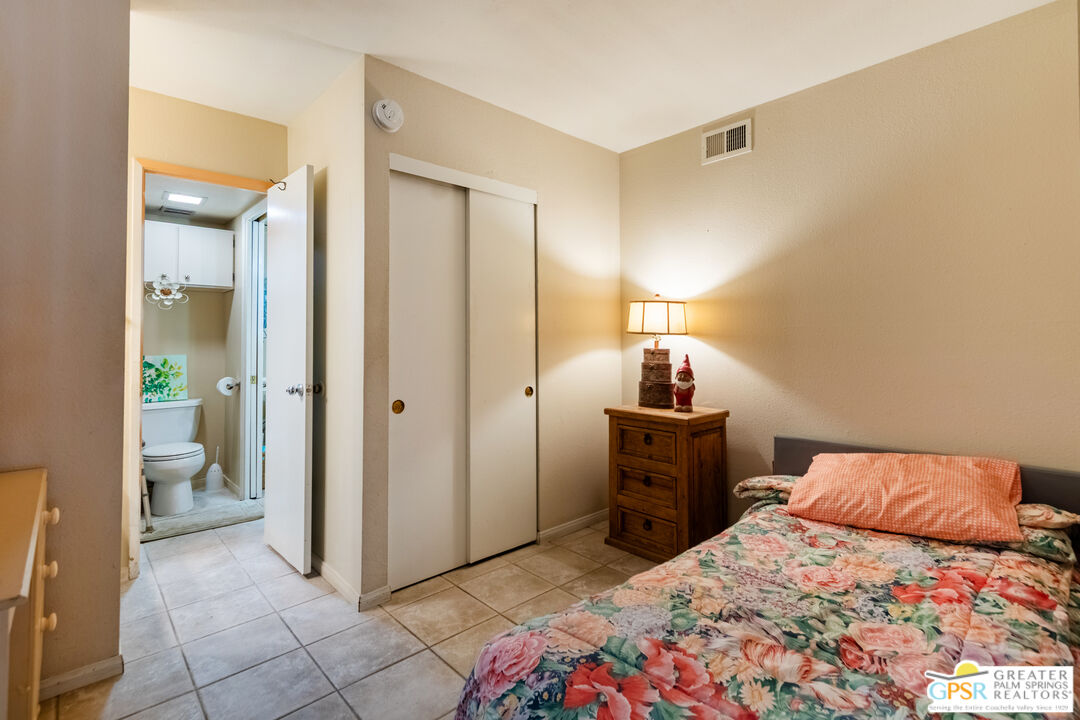 5300 East Waverly Drive, Unit C13 Palm Springs, CA 92264 - Photo 18 of 32 a bedroom with a bed and a mirror