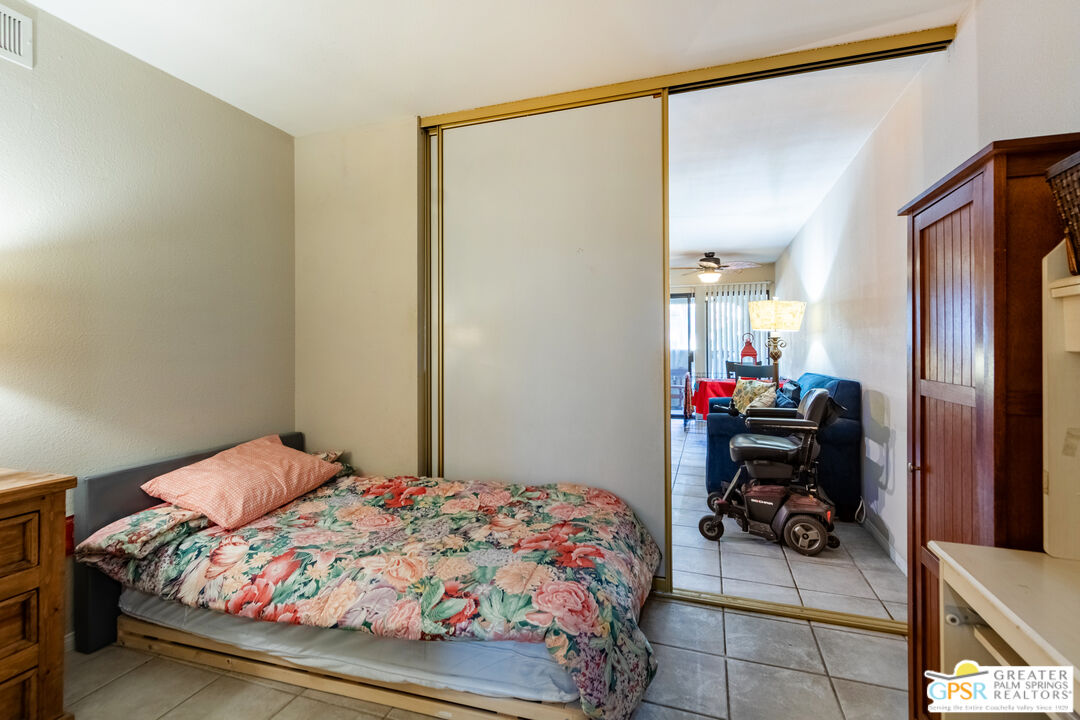 5300 East Waverly Drive, Unit C13 Palm Springs, CA 92264 - Photo 19 of 32 a bedroom with a bed and a mirror