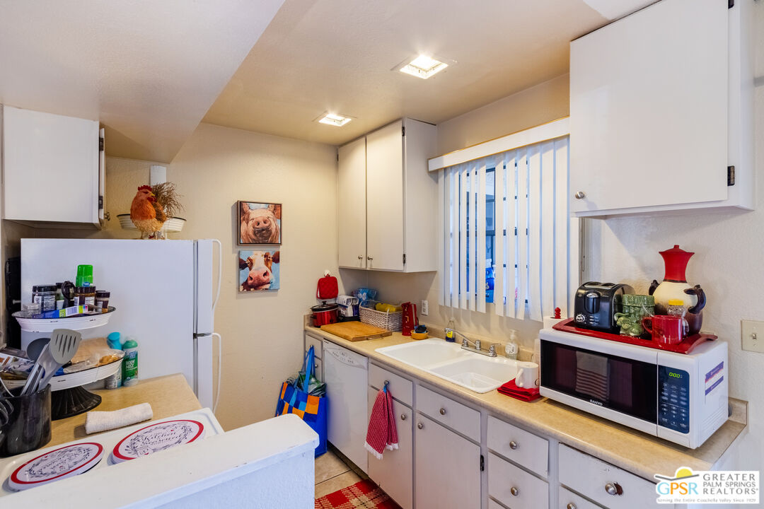 5300 East Waverly Drive, Unit C13 Palm Springs, CA 92264 - Photo 9 of 32 a utility room with cabinets a washer and dryer