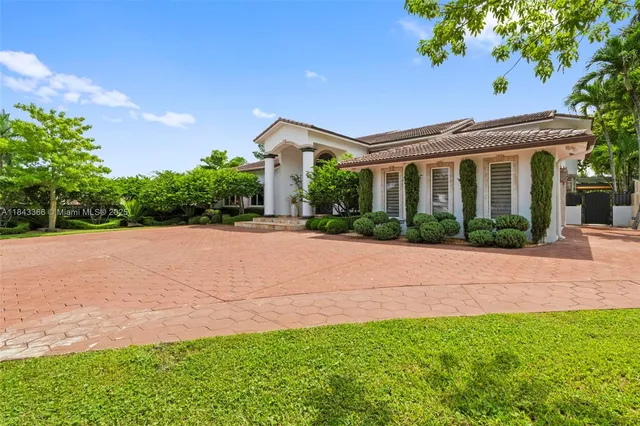 a front view of a house with a yard and potted plants