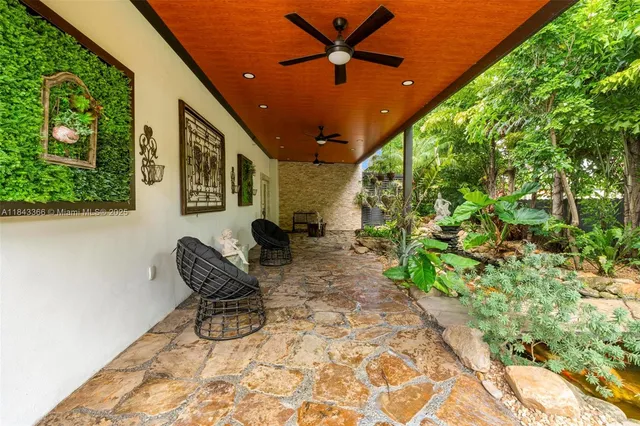 an aerial view of residential house with outdoor space and trees all around