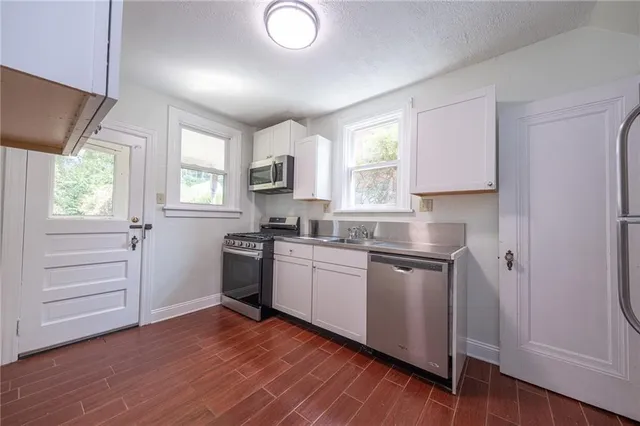 a kitchen with wooden floors and white appliances