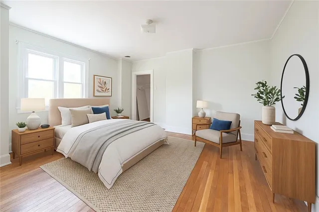 a spacious bedroom with a bed and wooden floor