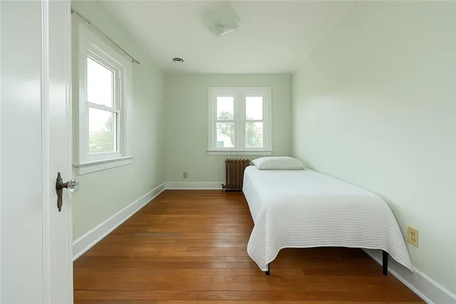 a bedroom with a bed and wooden floor