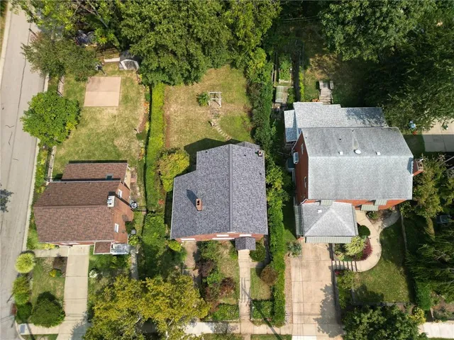 an aerial view of residential house with outdoor space and trees all around