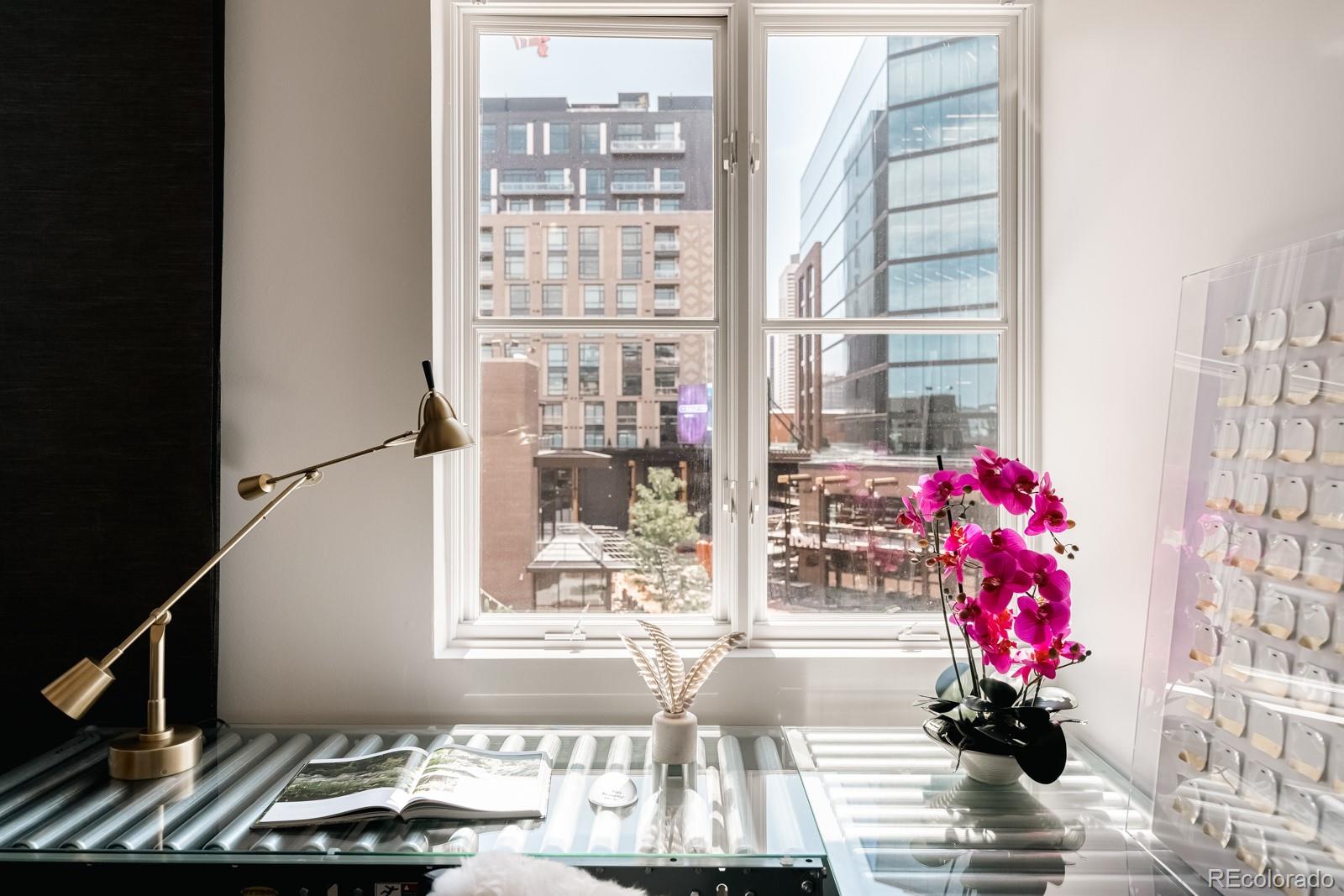 1735 19th Street, Unit 4A Denver, CO 80202 - Photo 16 of 25 a vase of flowers sitting on a table with a floor to ceiling window