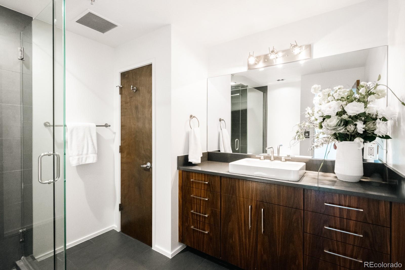 1735 19th Street, Unit 4A Denver, CO 80202 - Photo 6 of 25 a bathroom with a granite countertop sink and a mirror