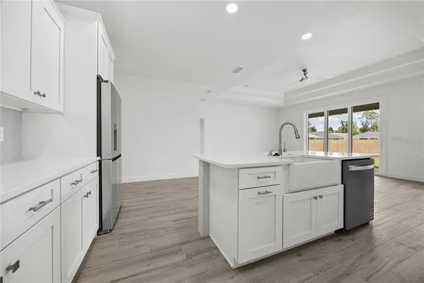 an empty room with wooden floor ceiling fan and windows