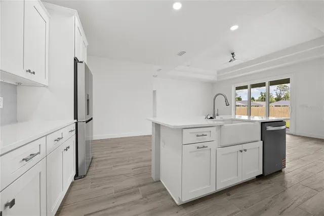 an empty room with wooden floor ceiling fan and windows