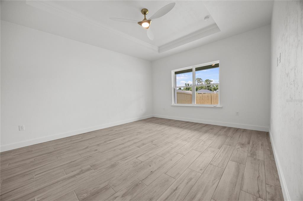 1018 Southwest 67th Drive Gainesville, FL 32607 - Photo 13 of 29 an empty room with wooden floor ceiling fan and windows