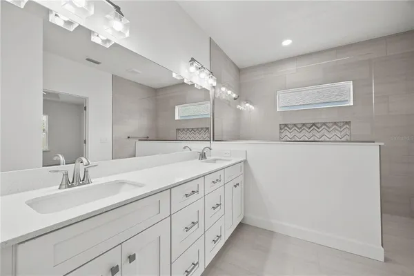 a bathroom with double vanity a and a shower