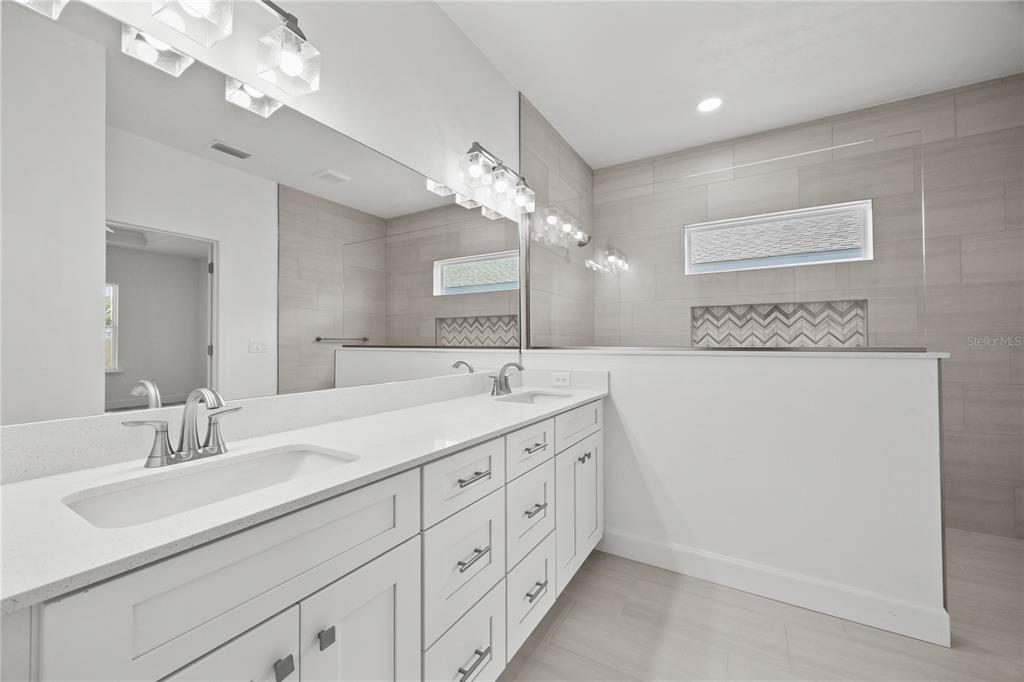 1018 Southwest 67th Drive Gainesville, FL 32607 - Photo 16 of 29 a bathroom with a double vanity sink and a mirror