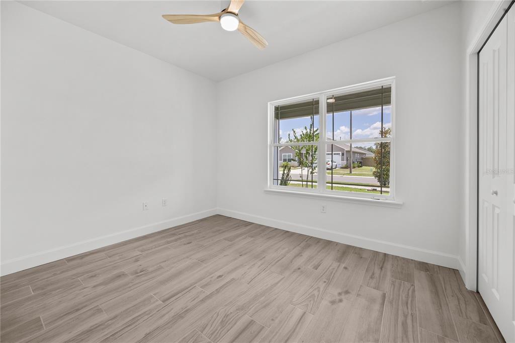 1018 Southwest 67th Drive Gainesville, FL 32607 - Photo 18 of 29 an empty room with wooden floor and windows