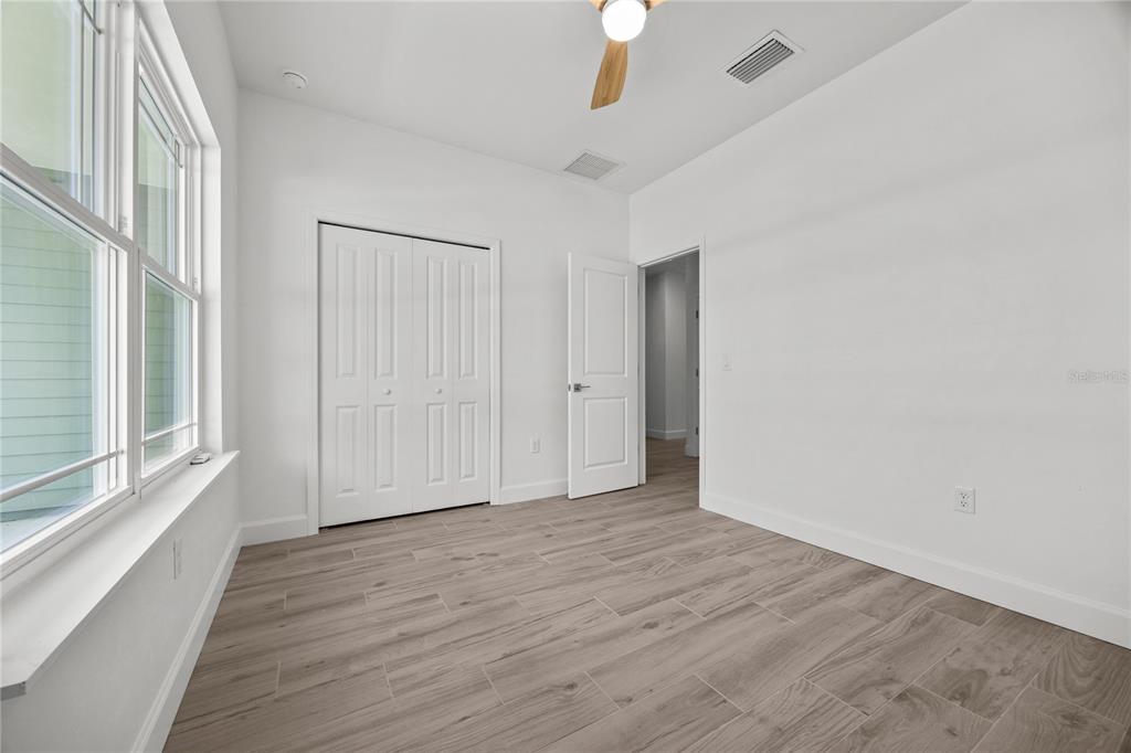 1018 Southwest 67th Drive Gainesville, FL 32607 - Photo 19 of 29 a view of an empty room with wooden floor and a window
